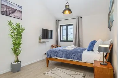 a bedroom with a bed and a tv on a wall at Basalt Dwelling II by Homie in São Vicente