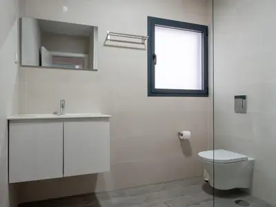 a bathroom with a toilet and a sink and a window at Apartamentos praia da Arrifana in Aljezur