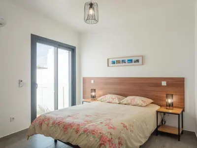 a bedroom with a large bed with a wooden headboard at Apartamentos praia da Arrifana in Aljezur