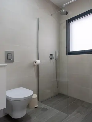 a bathroom with a toilet and a glass shower at Apartamentos praia da Arrifana in Aljezur