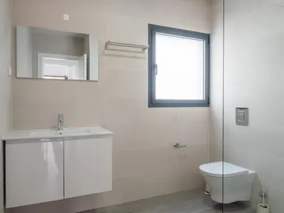 a white bathroom with a sink and a toilet at Apartamentos praia da Arrifana in Aljezur