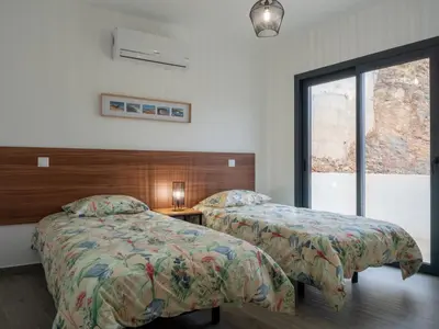 a bedroom with two beds and a window at Apartamentos praia da Arrifana in Aljezur