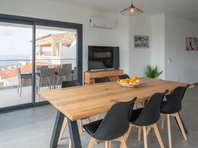 a dining room with a wooden table and chairs at Apartamentos praia da Arrifana in Aljezur