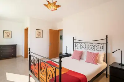a bedroom with a black bed with pink pillows at H2Ome by An Island Apart in Porto Santo