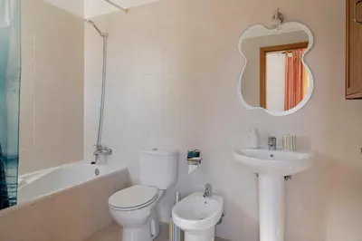 a bathroom with a toilet and a sink and a mirror at H2Ome by An Island Apart in Porto Santo