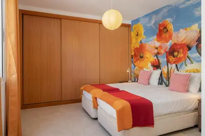 a bedroom with a bed with a painting of flowers at H2Ome by An Island Apart in Porto Santo