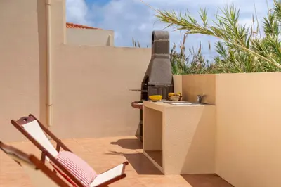 a patio with a table and a grill on a building at H2Ome by An Island Apart in Porto Santo