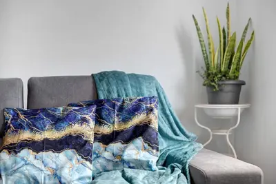 a blanket sitting on a chair with a plant at Casa da Ribeira da Janela in Porto Moniz
