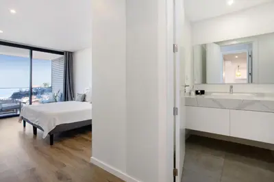 a bedroom with a bed and a sink and a mirror at Casa Castanheta in Câmara de Lobos
