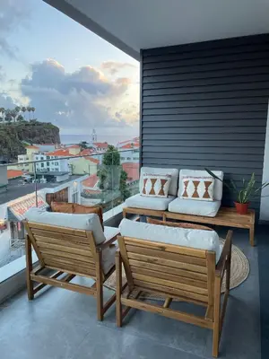 a balcony with two chairs and a couch at Casa Castanheta in Câmara de Lobos
