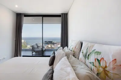 a bedroom with a bed with a large window at Casa Castanheta in Câmara de Lobos