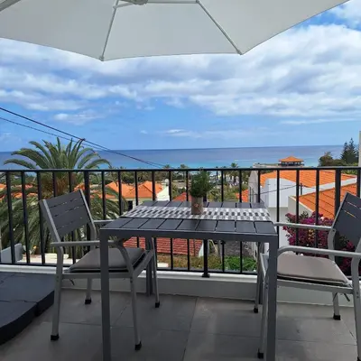 a table and chairs on a balcony with a view of the ocean at ALDABRA - CASA VACANZE EM PORTO SANTO in Porto Santo