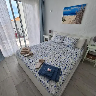a bedroom with a bed with sandals and towels on it at ALDABRA - CASA VACANZE EM PORTO SANTO in Porto Santo
