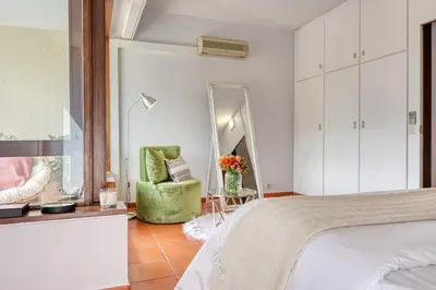 a bedroom with a green chair and a mirror at Monumental Tower, a Home in Madeira in Funchal