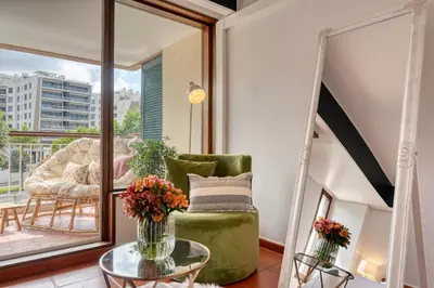 a living room with a green chair and a glass table at Monumental Tower, a Home in Madeira in Funchal