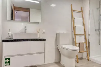 a bathroom with a white toilet and a sink at Monumental Tower, a Home in Madeira in Funchal