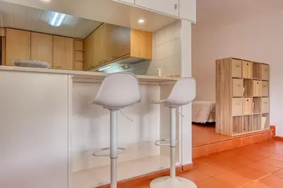 a kitchen with two white chairs in a room at Monumental Tower, a Home in Madeira in Funchal