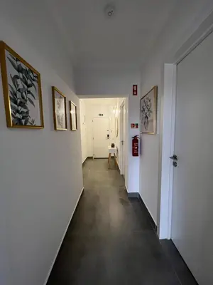 a hallway with white walls and a hallway with paintings on the walls at Retiro do Sossego in Sagres