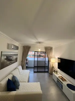 a living room with a white couch and a tv at Retiro do Sossego in Sagres