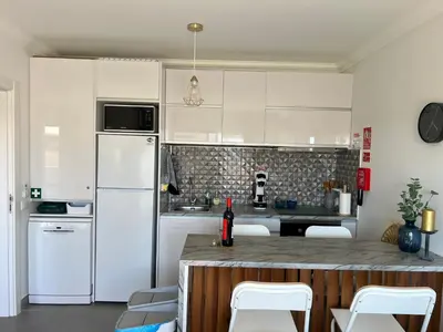a kitchen with white cabinets and a white refrigerator at Retiro do Sossego in Sagres