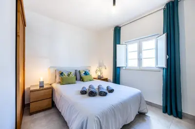 a bedroom with a bed with shoes on it at Casa Memória in Vila do Bispo