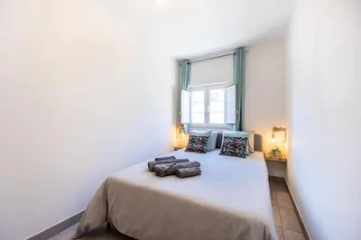 a bedroom with a large bed with a window at Casa Memória in Vila do Bispo