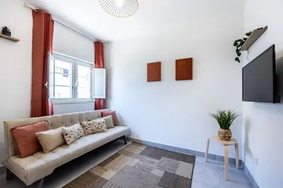 a living room with a couch and a tv at Casa Memória in Vila do Bispo