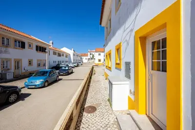 a row of cars parked on a street next to buildings at Casa Memória in Vila do Bispo