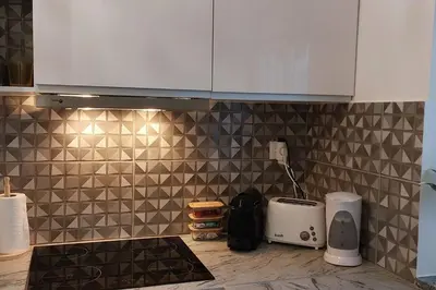 a kitchen with a tiled wall with a counter top at Casa Papillon in Sagres