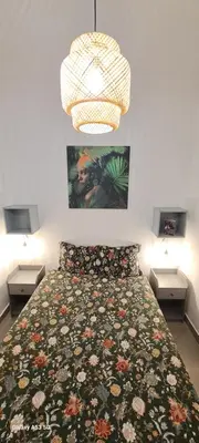 a bedroom with a bed with a floral bedspread at Casa Papillon in Sagres