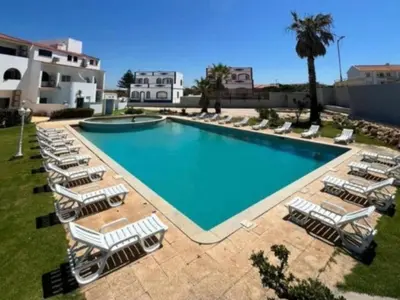 a large swimming pool with lounge chairs and a group at Casa Papillon in Sagres
