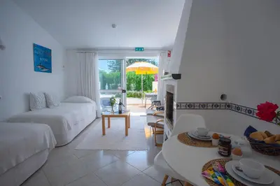 a white living room with a couch and a table at Charmingly furnished Studio with pool in Luz in Luz