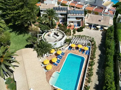 an aerial view of a resort with a swimming pool and umbrellas at Charmingly furnished Studio with pool in Luz in Luz