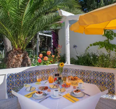a table with plates of food and an umbrella at Charmingly furnished Studio with pool in Luz in Luz