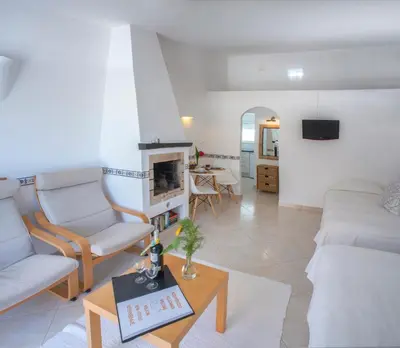 a living room with a couch and a fireplace at Charmingly furnished Studio with pool in Luz in Luz