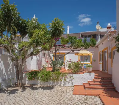 a house with a courtyard with trees and plants at 1 Bed Flat - Sleeps 2 - Pool - Parking - Wifi in Luz