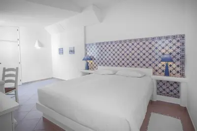 a bedroom with a white bed and a blue and white wall at 1 Bed Flat - Sleeps 2 - Pool - Parking - Wifi in Luz