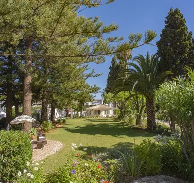 a garden with trees and a house in the background at 1 Bed Flat - Sleeps 2 - Pool - Parking - Wifi in Luz