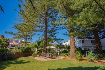 a yard with trees and a bench in front of a house at 1 Bed Flat - Sleeps 2 - Pool - Parking - Wifi in Luz
