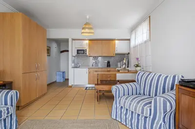 a living room with two chairs and a kitchen at Casa Anaim by Homie in Porto Santo