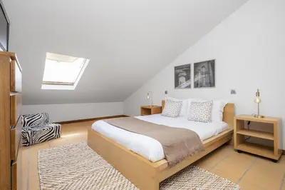 a bedroom with a large white bed and a rug at Casa Anaim by Homie in Porto Santo