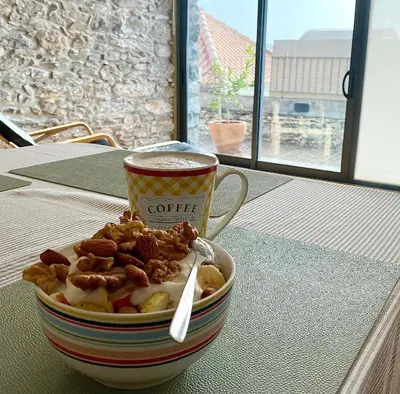 a cup of coffee and a bowl of food on a table at Casa dos Arrifes - Villa with Ocean view and private Garden in Funchal