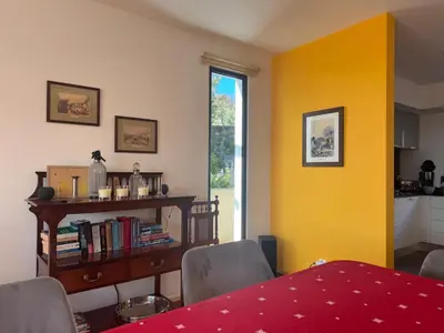 a living room with a table and a yellow wall at Casa dos Arrifes - Villa with Ocean view and private Garden in Funchal