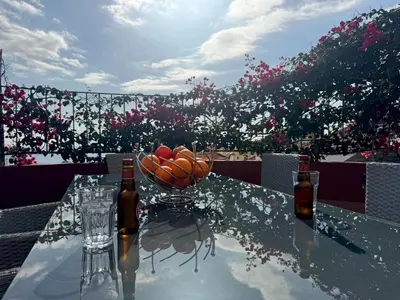 a table with two bottles and a bowl of fruit at Casa dos Arrifes - Villa with Ocean view and private Garden in Funchal