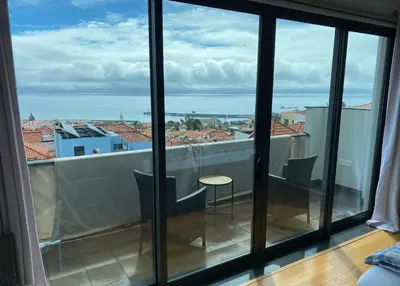 a room with a view of the ocean from a balcony at Casa dos Arrifes - Villa with Ocean view and private Garden in Funchal