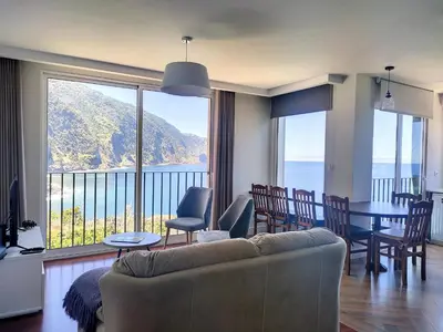 a living room with a couch and a view of the ocean at Holiday`s House 