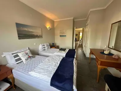 two beds in a room with a desk and a bed sidx sidx sidx at Casa Buccaneer, 2 Bedroom Garden Apartment in Praia da Luz in Luz