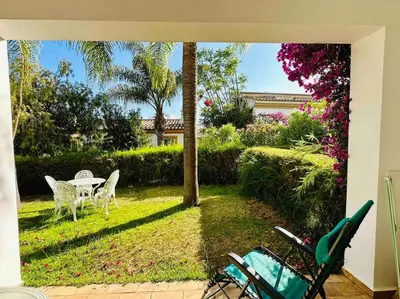 a patio with a table and chairs in a yard at Casa Buccaneer, 2 Bedroom Garden Apartment in Praia da Luz in Luz