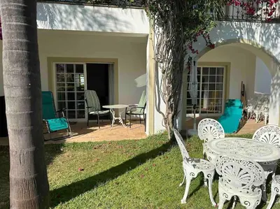a table and chairs in a yard with a patio at Casa Buccaneer, 2 Bedroom Garden Apartment in Praia da Luz in Luz