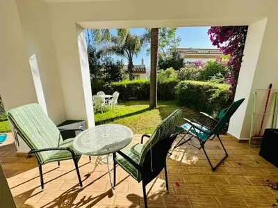 a patio with four chairs and a table and a garden at Casa Buccaneer, 2 Bedroom Garden Apartment in Praia da Luz in Luz